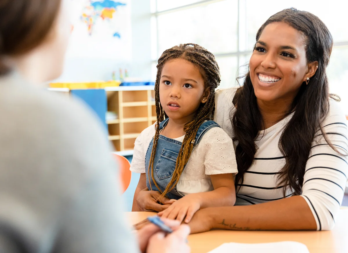 mother and daughter talking to teacher
