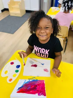 little girl working on art project at preschool